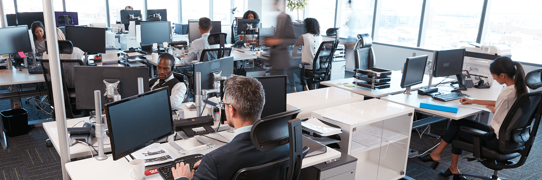 A busy office setting with people working at desks