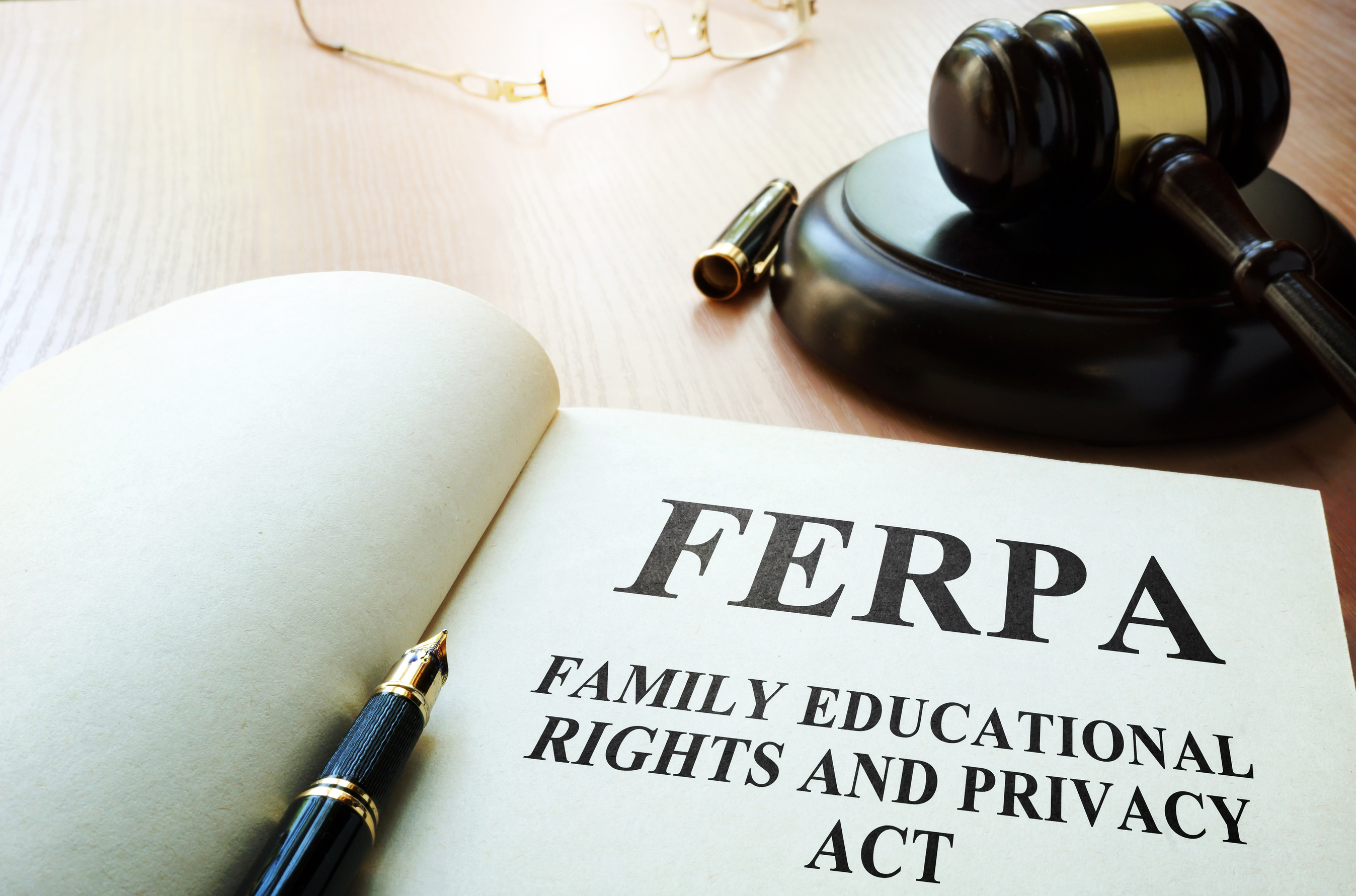 An image of an open about FERPA compliance sitting open next to a gavel.