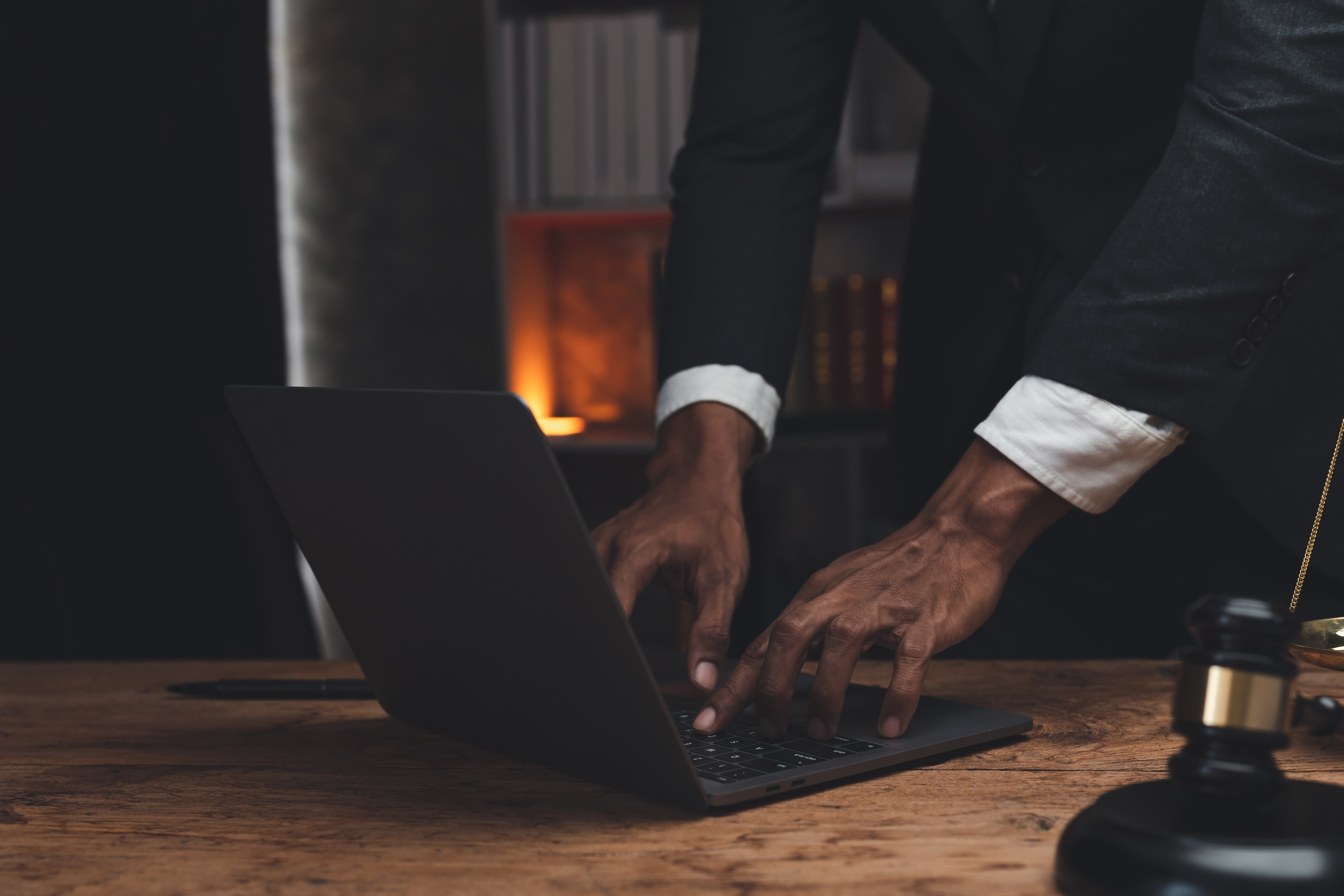 An image of a lawyer typing on a secure laptop because the law firm outsources managed IT services.