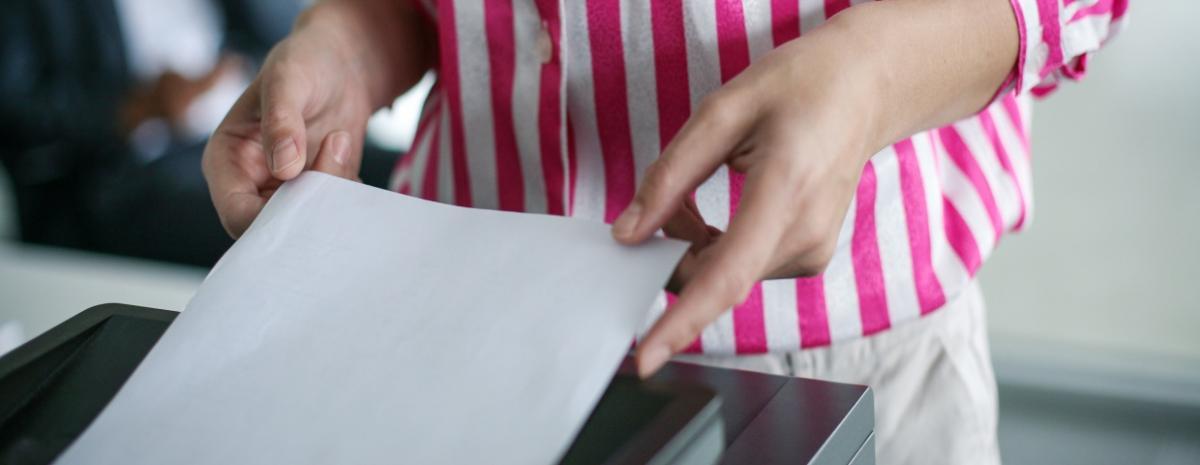 woman inserting paper in a copier