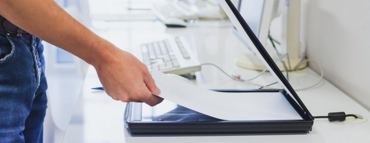 man putting paper in scanner